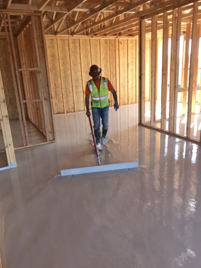 Insul-Flow employee applys gypsum flooring in new construction 